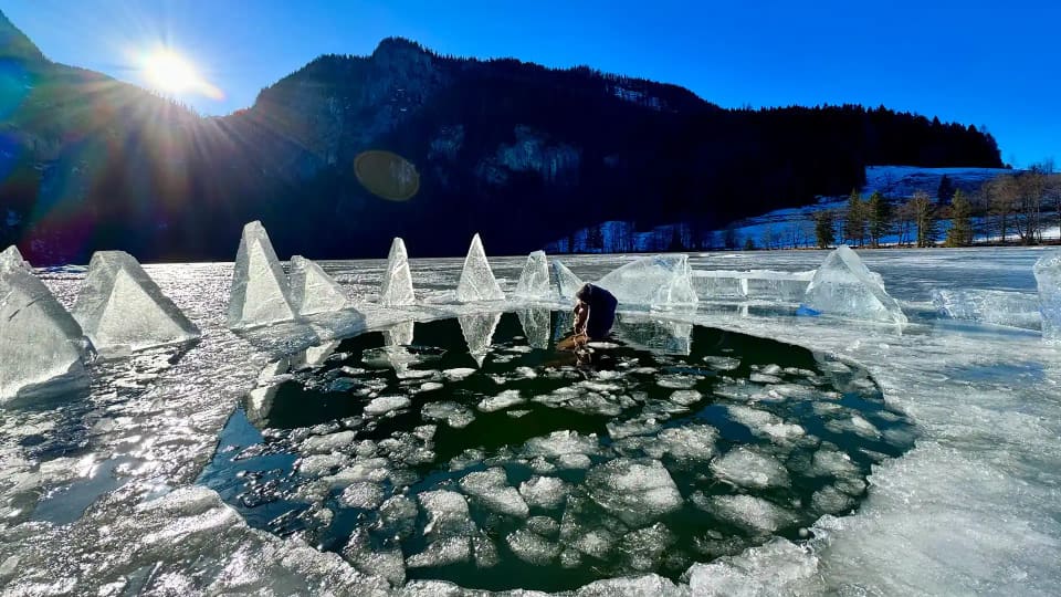 Freigeschlagenes Eisloch vor Bergkulisse